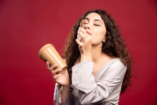 Foto gratuita donna elegante che gode del suo caffè e cioccolato.