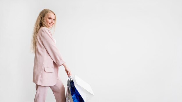 Elegant woman holding shopping bags with copy space