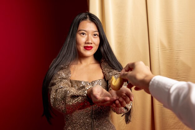 Бесплатное фото Шикарная женщина получая печенье с предсказанием на китайский новый год