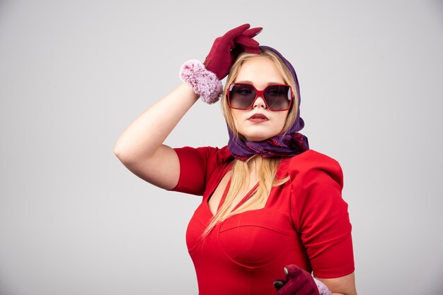 Elegant woman in red dress posing to camera. 