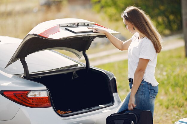 Elegant woman removes the suitcase from the trunk