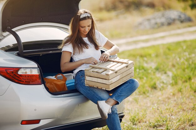 Elegant woman sitting in a trunk with wood box