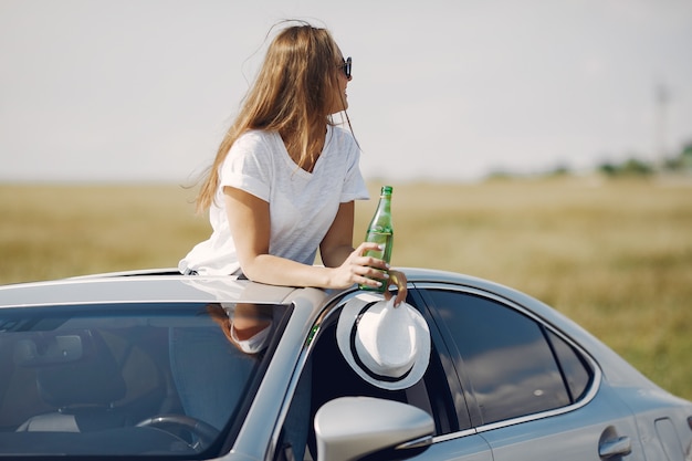 Elegant woman standing bin a hatch of the car