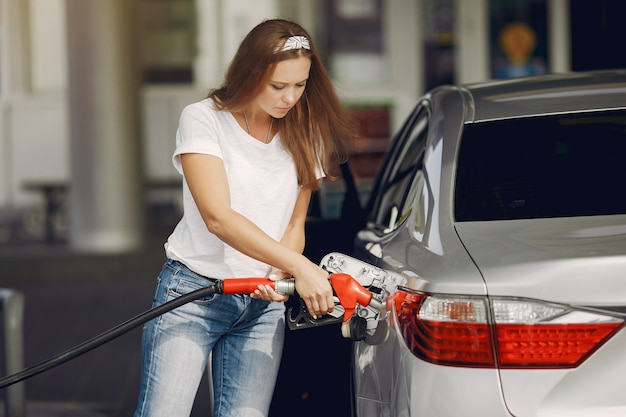 ガソリンスタンドに立っているエレガントな女性