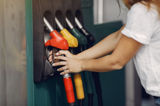 ガソリンスタンドに立っているエレガントな女性