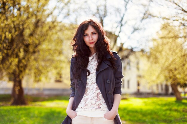 Elegant woman standing with hands in pockets