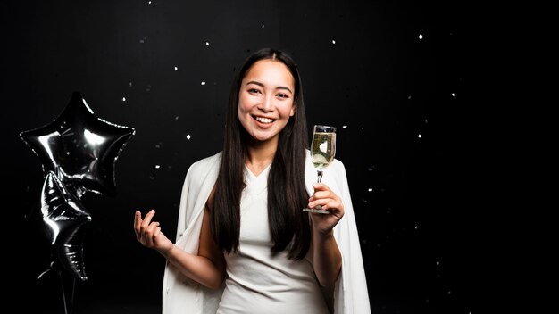 Elegant woman toasting with champagne and balloons