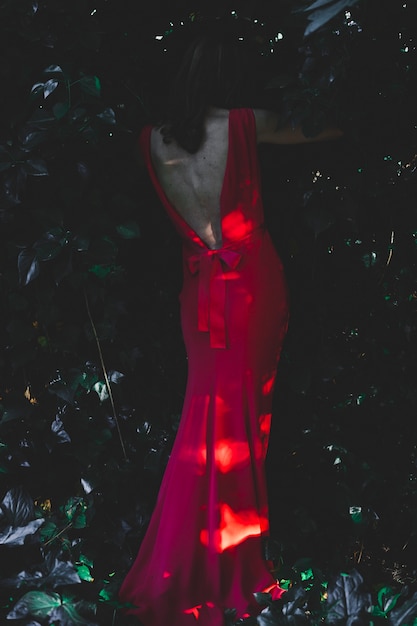 Free photo elegant woman walking through bushes