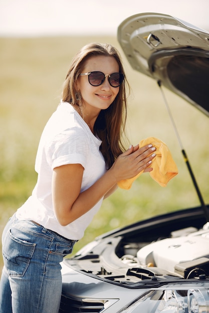 エレガントな女性がぼろで車を拭く