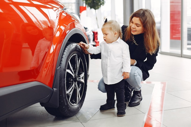 車のサロンで小さな娘とエレガントな女性