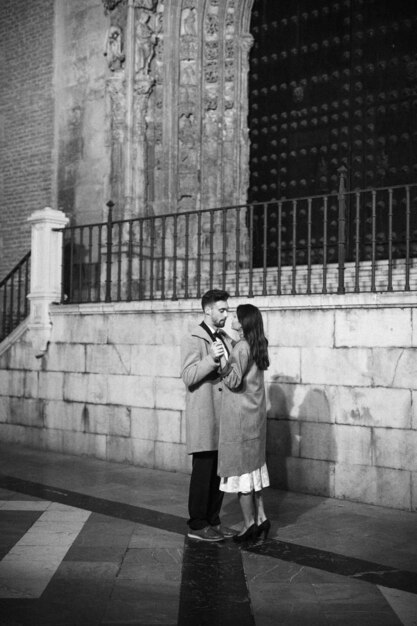 Elegant woman and young man holding hands on street 