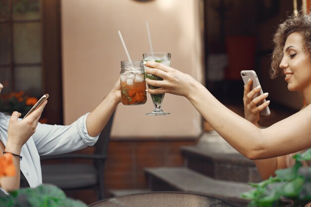 エレガントな女性が夏の街でカクテルを飲む