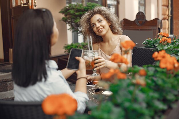 エレガントな女性が夏の街でカクテルを飲む