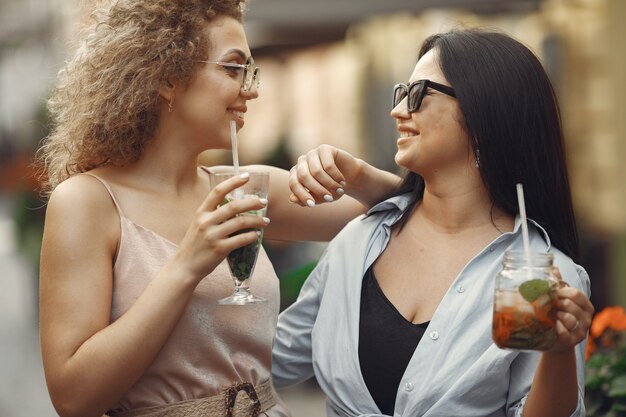 エレガントな女性が夏の街でカクテルを飲む