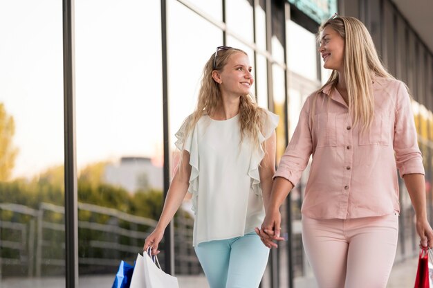 Элегантные женщины счастливы вместе за покупками