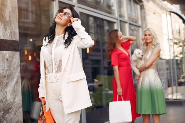 elegant women with shopping bags in a city