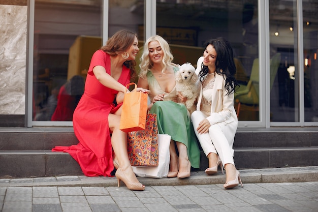 elegant women with shopping bags in a city