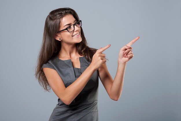 Elegant young businesswoman pointing at side