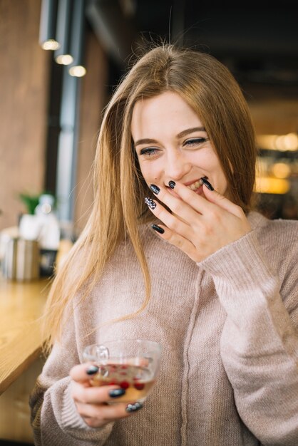 Foto gratuita giovane donna di risata elegante con la tazza della bevanda in caffè