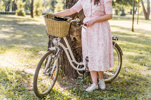 자전거와 함께 포즈를 취하는 우아한 젊은 여자