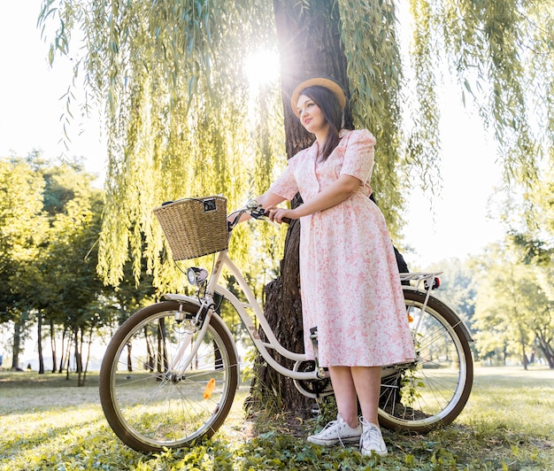 自転車でポーズをとってエレガントな若い女性