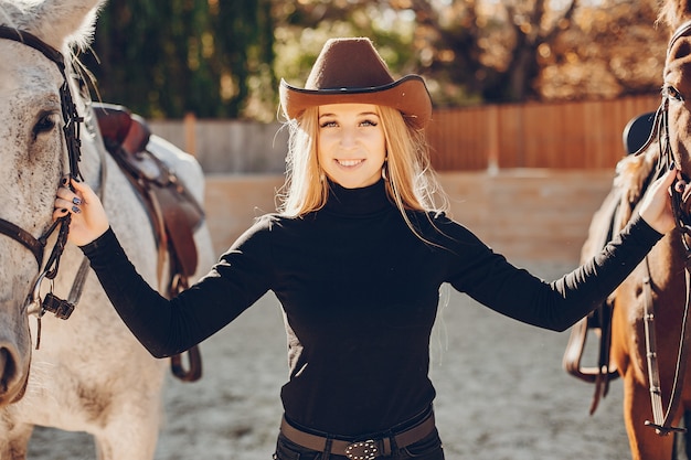 牧場で馬を持つ優雅な女の子