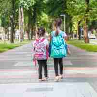 Foto gratuita studenti elementari, portando zaini che vanno in classe