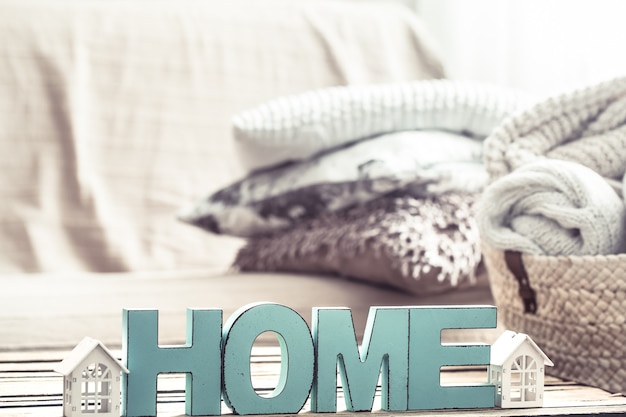 elements of home cozy decor on the table in the living room with wooden letters with the inscription home .