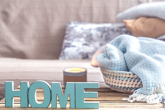 elements of home cozy decor on the table in the living room with wooden letters with the inscription home .