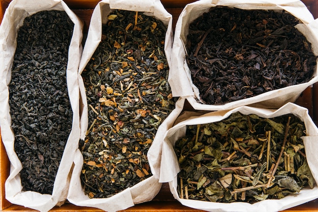 Free photo an elevated view of assortment of dry tea in paper bag