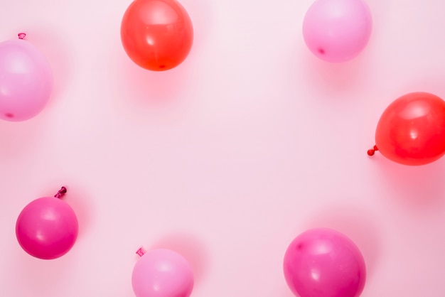 Una vista elevata di palloncini su sfondo rosa