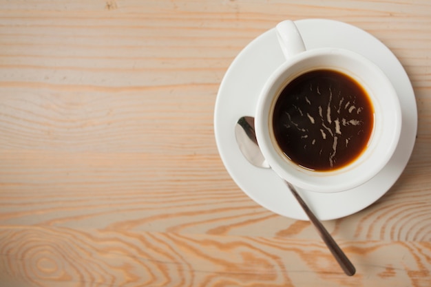 Elevated view of black coffee on wooden table