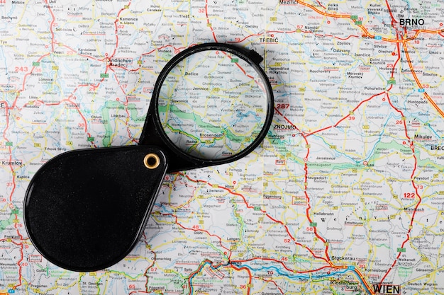 Free photo elevated view of black magnifying glass on map