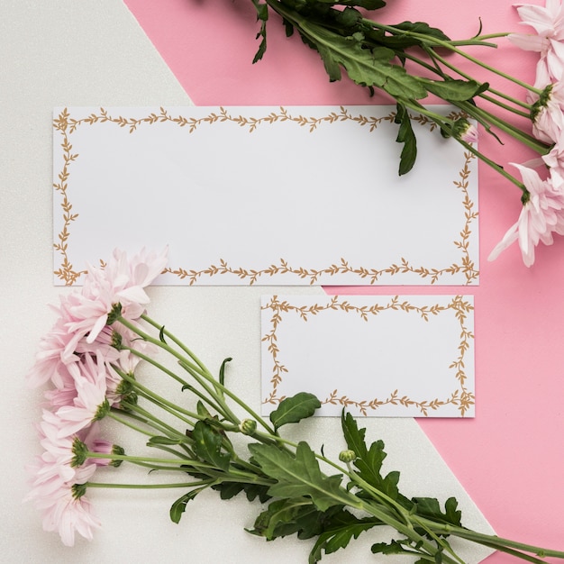Elevated view of blank card with fresh flowers on dual background