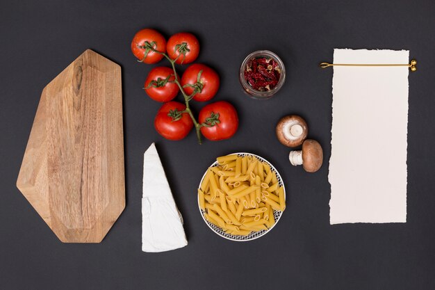 Elevated view of blank white paper and healthy ingredient for making tasty pasta 