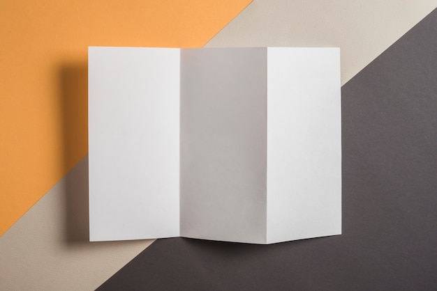 Elevated view of blank white paper on multi colored background