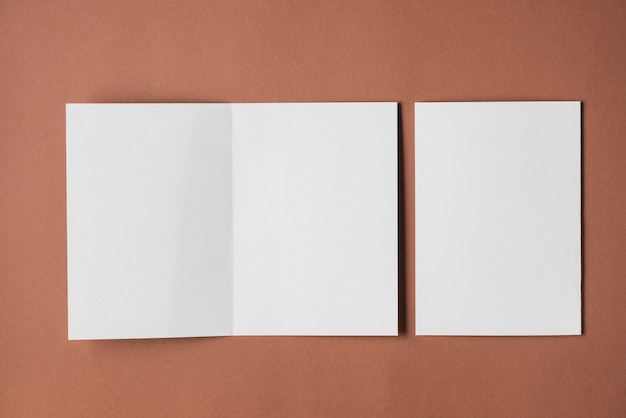 Free photo elevated view of blank white papers on brown backdrop