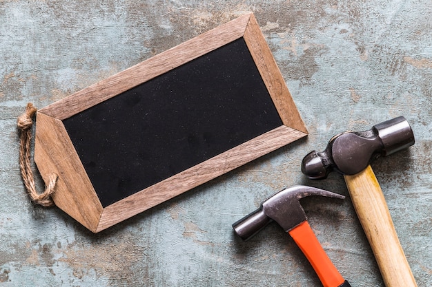 Elevated view of blank wooden tag and two hammers