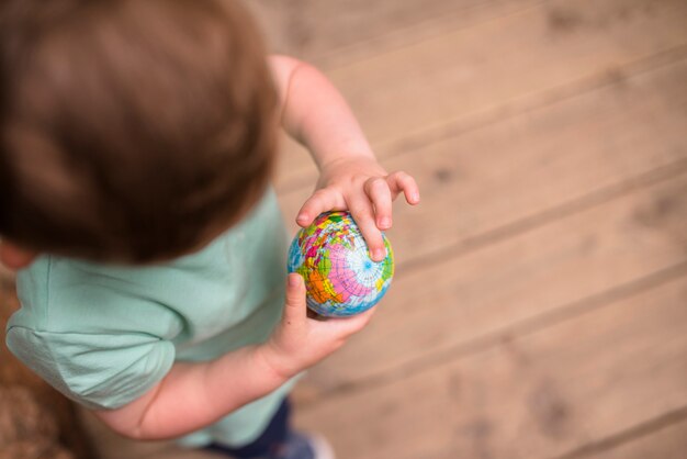 An elevated view of boy looking at globe ball