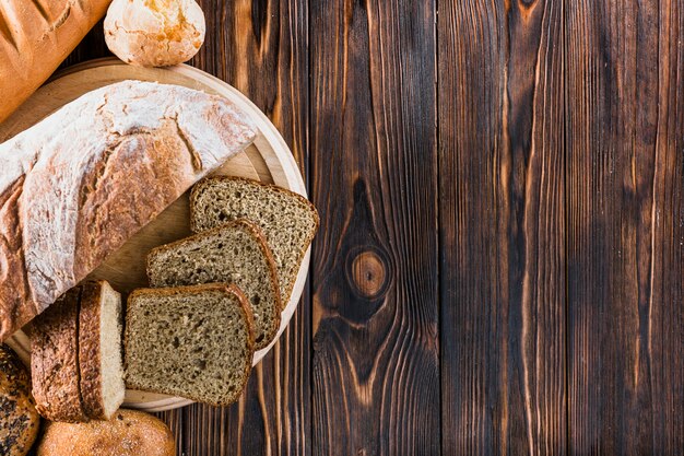 Elevated view of bread loves on dark wooden table