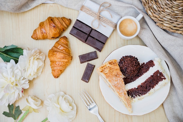 Foto gratuita vista elevata di colazione con fiori sul tavolo di legno