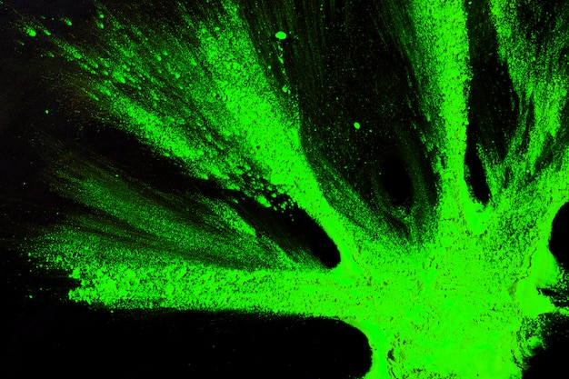 Foto gratuita vista elevata del colore verde brillante di holi sulla superficie del nero