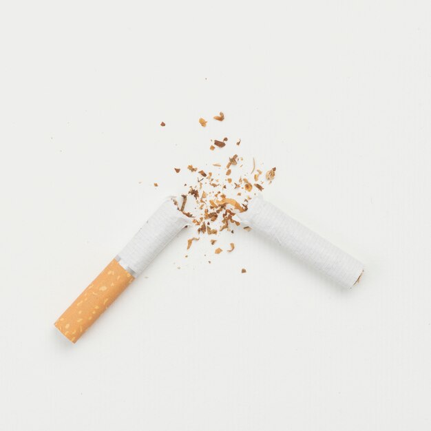 Elevated view of broken cigarette on white backdrop