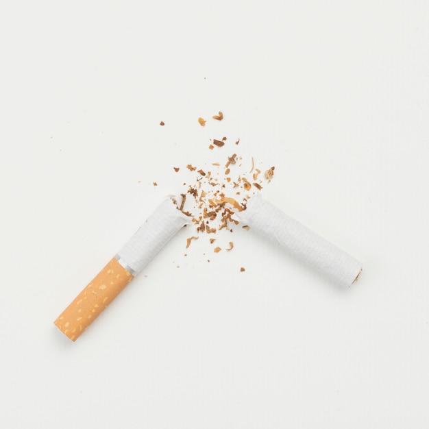 Elevated view of broken cigarette on white backdrop