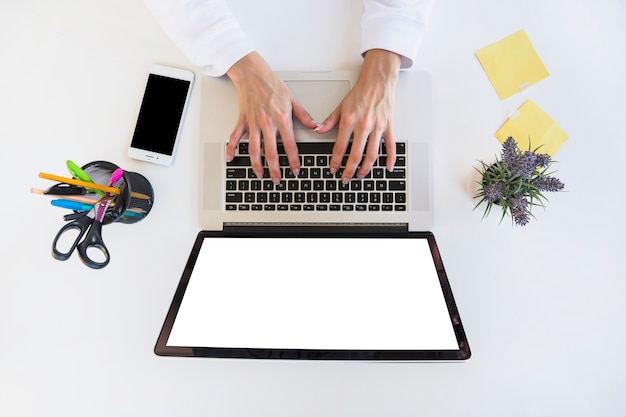 Vista elevata della mano di un uomo d'affari utilizzando il computer portatile sulla scrivania