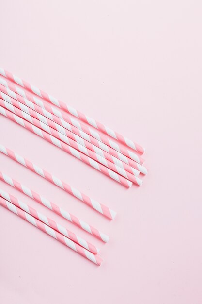 Elevated view of candy canes on pink background