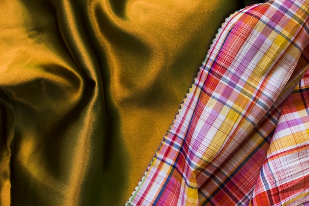 Elevated view of chequered pattern table cloth on silky golden textile