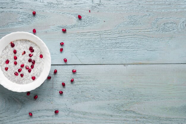 An elevated view of chia seed pudding in white bowl on wooden table