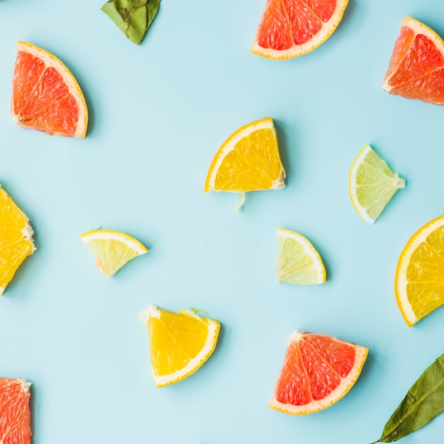 Elevated view of citrus fruit slices on blue background