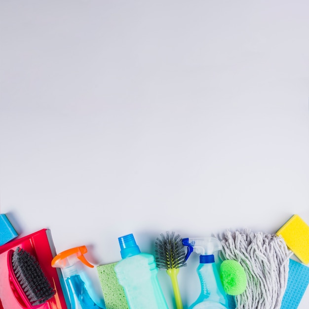 Elevated view of cleaning equipments at the bottom of grey background